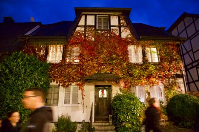 Mit Wein bewachsenes Haus mit hellen Fenstern