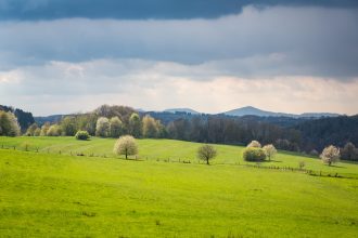 dunkle Wolken über grünen Hügeln