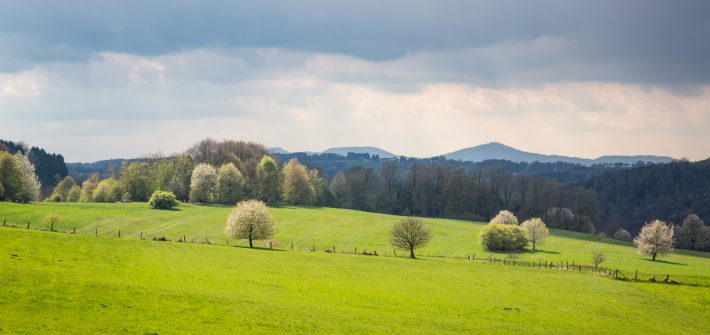 dunkle Wolken über grünen Hügeln