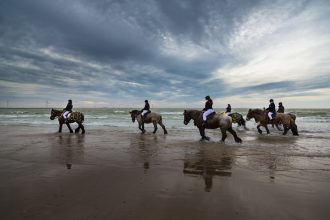 Reiter vor beeindruckendem Wolkenhimmel über der Nordsee