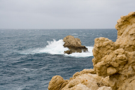 Wellenbrecher ein Felsen im Meer an dem Wellen brechen