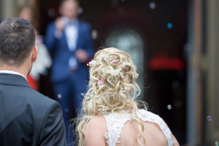 Braut und Bräutigam freuen sich über den Vorhang aus Seifenblasen Ein Regen aus Seifenblasen