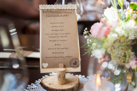 fein gestaltete Getränkekarte neben Blumenstraus Das gab es zu trinken