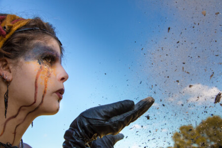 Frau bläst Asche in den Himmel Asche zu Asche