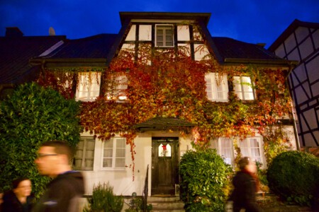 Mit Wein bewachsenes Haus mit hellen Fenstern Licht in den Fenstern